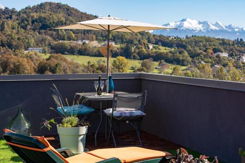 a patio with an umbrella and a table and chairs at B&B Giardini dell'Ardo in Belluno