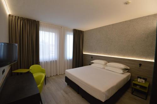 a hotel room with a bed and a television at Hotel Friuli in Udine