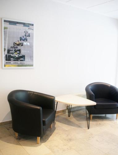 two black chairs and a table in a room at Taste Hotel Hockenheim in Hockenheim