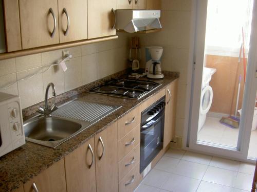 a kitchen with a sink and a stove at APCOSTAS - Hawaii Sun in La Manga del Mar Menor