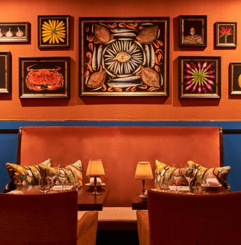 a room with two chairs and paintings on the wall at The Bird, Bath in Bath