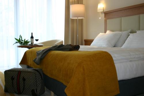 a hotel room with a bed with a blanket on it at Hotel Hanseatic - Adults Only in Kołobrzeg