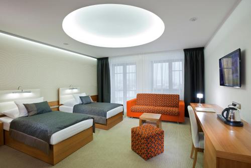 a hotel room with two beds and a desk at Hotel Vitality in Vendryně