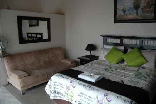 a bedroom with a bed and a couch at Bon A Vie Self-catering and b&b Gonubie Full Solar Power, no load shedding! in Gonubie