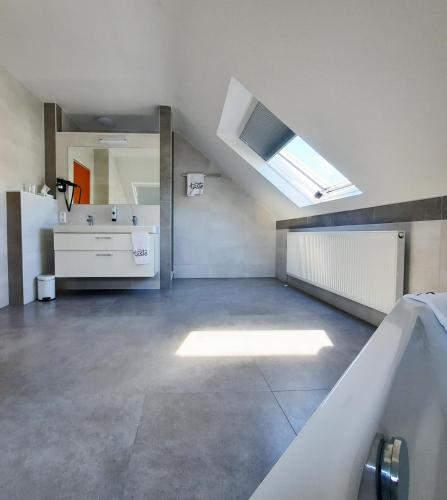 a large bathroom with a sink and a mirror at Taste Hotel Hockenheim in Hockenheim