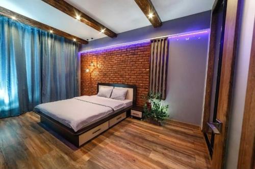 a bedroom with a bed and a brick wall at Apartament on Gorkogo 23 in Bobruisk