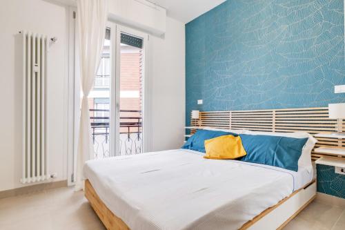 ein Schlafzimmer mit einem großen Bett mit blauer Wand in der Unterkunft Vista su San Luca Apartment in Bologna