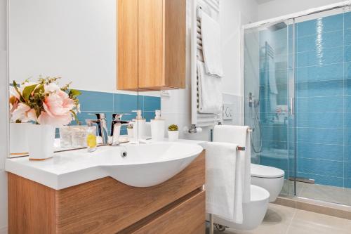 La salle de bains est pourvue d'un lavabo blanc et de toilettes. dans l'établissement Vista su San Luca Apartment, à Bologne