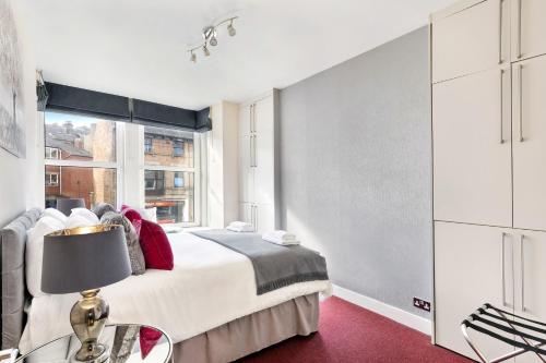 a bedroom with a bed and a window at Granville Apartments Harrogate in Harrogate