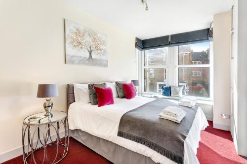 ein Schlafzimmer mit einem großen Bett und einem Fenster in der Unterkunft Granville Apartments Harrogate in Harrogate