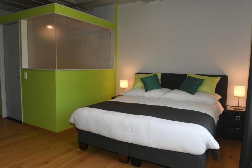 a bedroom with a large bed with a green wall at Auberge de Bellelay Restaurant Chez Aron Balde in Bellelay
