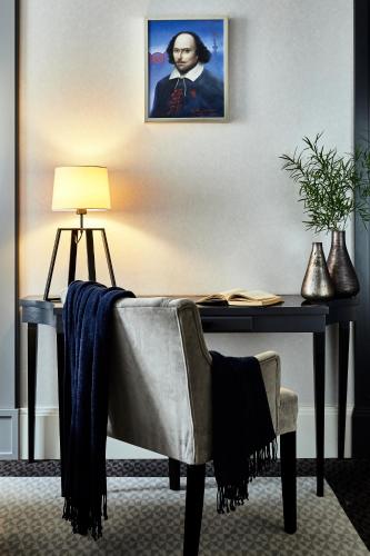 a desk with a chair and a table with a lamp at Hotel Teatro Boutique Old Town - Destigo Hotels in Warsaw