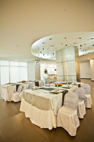 a banquet hall with white tables and white chairs at The Exchange Regency Residence Hotel Managed by HII in Manila
