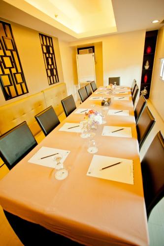 a large conference room with a long table with chairs at The Exchange Regency Residence Hotel Managed by HII in Manila