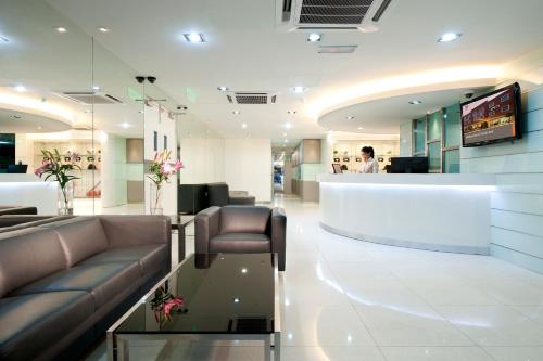 uma sala de espera com um sofá e um balcão em Fenix Inn em Malaca