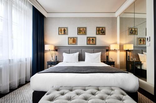 a bedroom with a large bed and a large window at Teatro Hotel in Warsaw