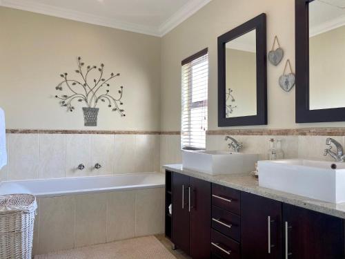 a bathroom with two sinks and a tub and a mirror at Barbados 13, Caribbean Estate - PRIVATE POOL!! in Port Edward