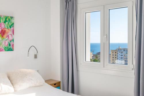 a bedroom with a window with a view of the ocean at Villa Harmonía en Palma piscina/mar/playa in Palma de Mallorca