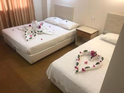 two beds with flowers on them in a bedroom at Unver Holiday Homes in Marmaris