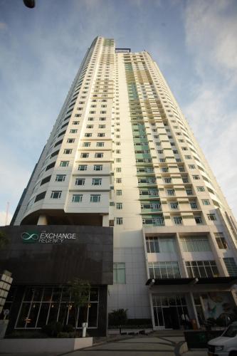 a tall white building with a car parked in front of it at The Exchange Regency Residence Hotel Managed by HII in Manila