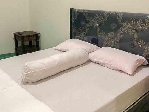 un letto bianco con due cuscini sopra di Griya Fadamas Syariah near Taman Hijau Demangan Madiun Mitra RedDoorz a Madiun
