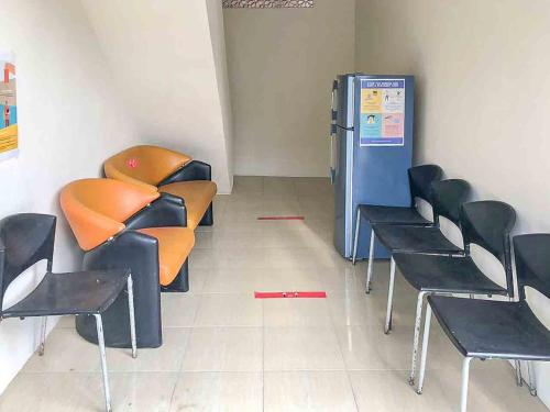 a waiting room with chairs and a refrigerator at Griya Fadamas Syariah near Taman Hijau Demangan Madiun Mitra RedDoorz in Madiun
