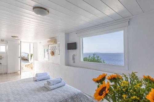 ein weißes Zimmer mit einem Bett und einem Fenster in der Unterkunft Sea Wind Apartments in Agios Stefanos