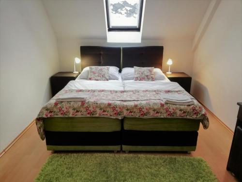 a bedroom with a large bed with a green rug at Penzion Panda 2 in Turčianske Teplice