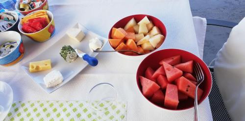 a table with two bowls of fruit and cheese at La Fontanella Apartment in Polverara