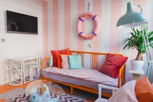 ein Sofa mit bunten Kissen im Wohnzimmer in der Unterkunft The Courtyard Suite by Margate Suites in Margate