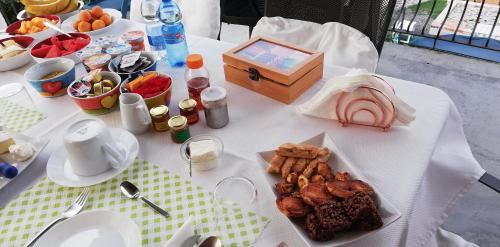 a white table with a plate of food on it at La Fontanella Apartment in Polverara