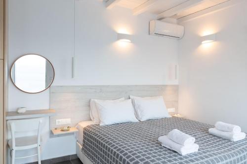 a small bedroom with a bed and a mirror at Sea Wind Apartments in Agios Stefanos