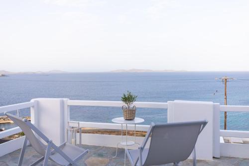 a table and chairs on a balcony overlooking the ocean at Sea Wind Apartments in Agios Stefanos