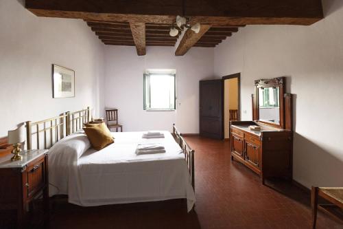 a bedroom with a large white bed and a dresser at Razza del Casalone in Grosseto