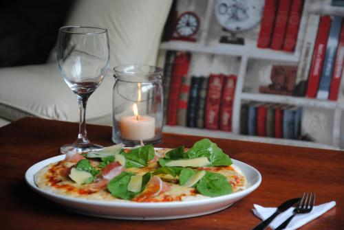a plate of pizza with a candle and a wine glass at Blu Inn in Punta del Este