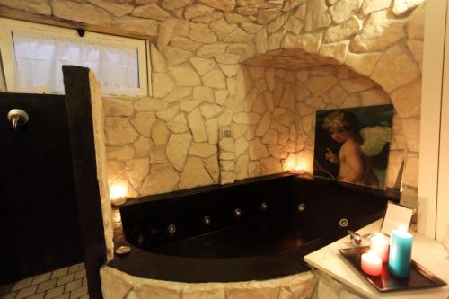 a woman in a bath tub in a stone bathroom at Appartamento La Chicca in Sermoneta