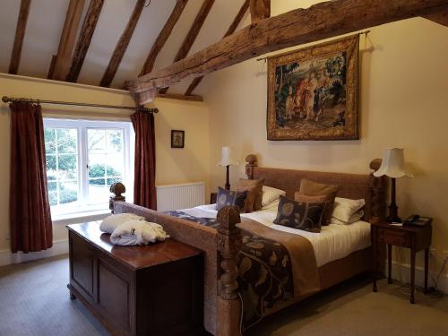 a bedroom with a bed and a painting on the wall at Hintlesham Hall Hotel in Ipswich