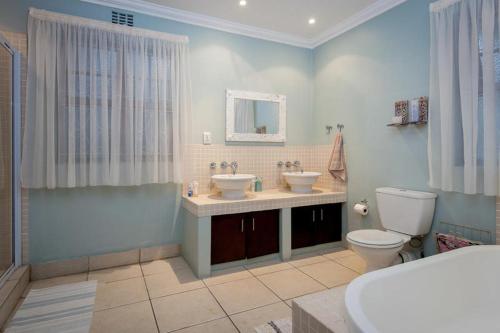 y baño con 2 lavabos, aseo y espejo. en The Brother's Guest House, en Durban
