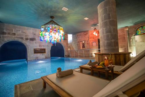 una gran piscina cubierta con una lámpara de araña en Imperial Cave Suites & Spa, en Göreme
