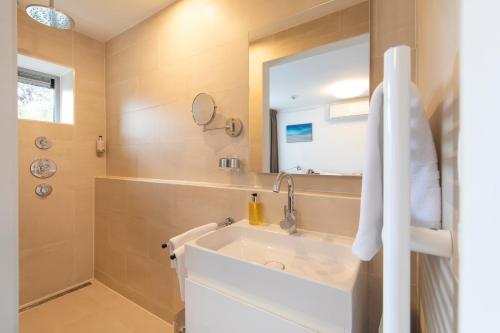 a bathroom with a sink and a mirror at Hotel La Rosa Amsterdam Beach in Zandvoort