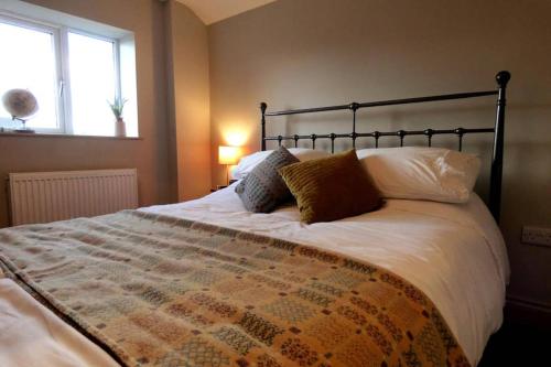 a bedroom with a large bed with white sheets and pillows at Y Cwtsh in Llandeilo