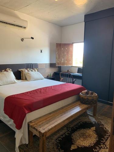 1 dormitorio con 1 cama grande y banco de madera en Casa Canoa - climatizada e com piscina, en Piranhas