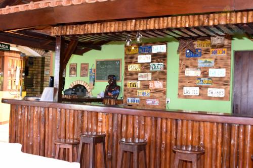 a bar with wooden walls and stools in a restaurant at Hotel Pousada Viking in Jacumã