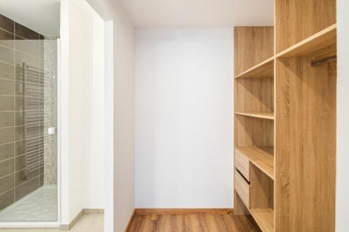 a bathroom with a walk in closet with wooden shelves at Maison Elleviou - Grande Maison à deux pas du centre in Rennes