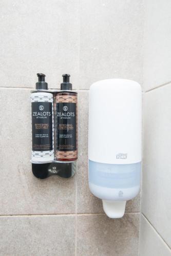 two bottles of shampoo and a soap dispenser in a bathroom at Tsikeli Boutique Hotel Meteora - Adults Friendly in Kalabaka