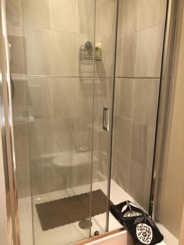 La salle de bains est pourvue d'une douche avec une porte en verre. dans l'établissement Grange House Bed & Breakfast, à Lowdham