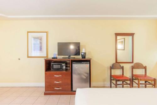 a living room with a tv and a refrigerator at Days Inn by Wyndham Shenandoah in The Woodlands