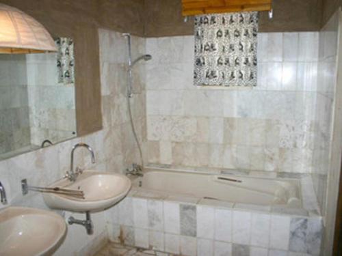 a bathroom with a tub and a sink and a bath tub at Fort Sesfontein Lodge & Safaris in Sesfontein