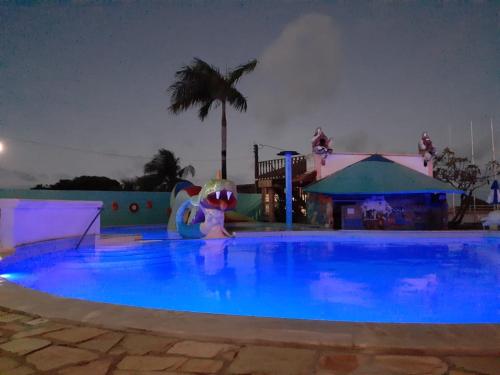 a large swimming pool at a theme park at night at Hotel Pousada Viking in Jacumã