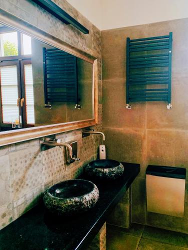 two sinks in a bathroom with a mirror at Dwór Karwacz in Przasnysz